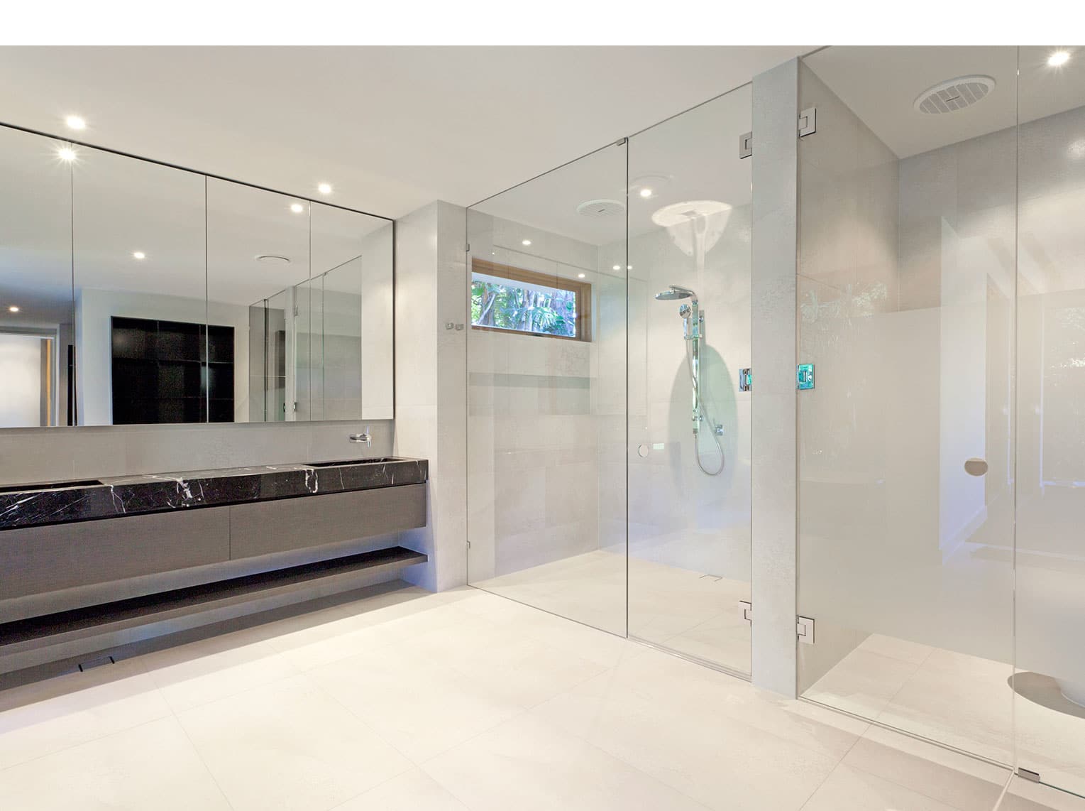 Bathroom with glass shower screens and mirror