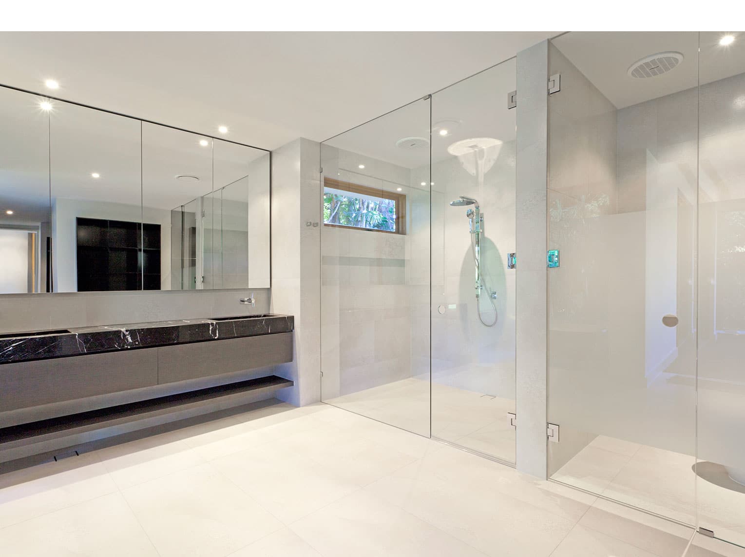 Bathroom with frameless glass shower screens and large bathroom mirror