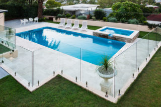 Modern Swimming Pool With Glass Fence — Frameless Shower Installations in Maroochydore, QLD